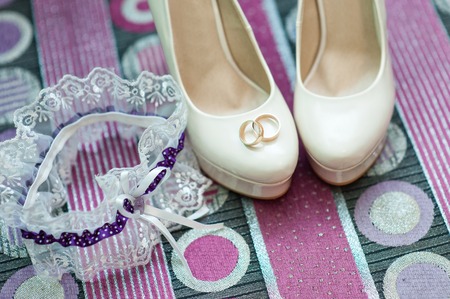 still life with wedding bride shoes and garter and gold rings.の写真素材