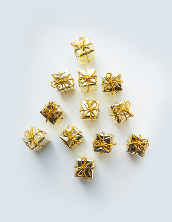 Christmas gifts wrapped in gold on white bacground.の写真素材