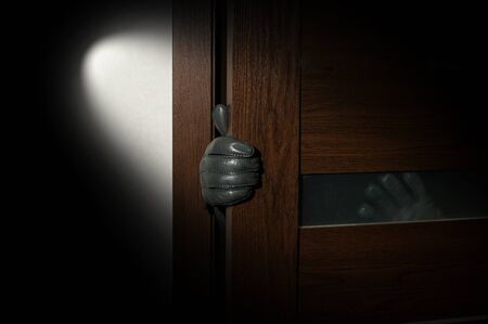 man's hand in a black glove open the door.の写真素材