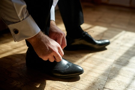 Business man tying shoe laces on the floor. Close-up.の写真素材