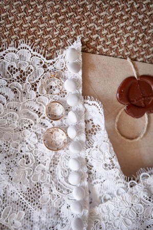wedding rings from yellow gold lie on a dress of the bride.の写真素材
