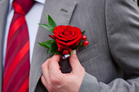 groom in red tie with rose on his jacket.の写真素材