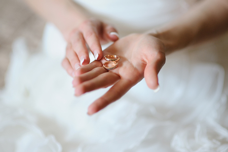 Bride holds on the palm two gold rings.の写真素材