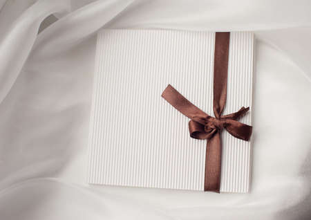 white envelope with brown ribbon with a bow and place for text.の写真素材