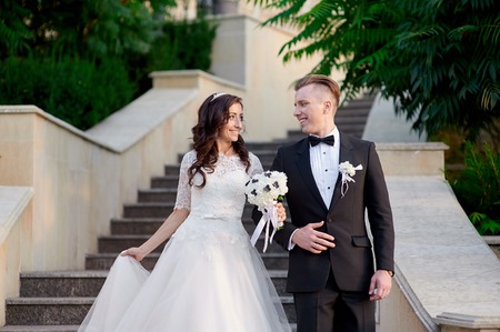bride and groom walking up the stairs in the park.
