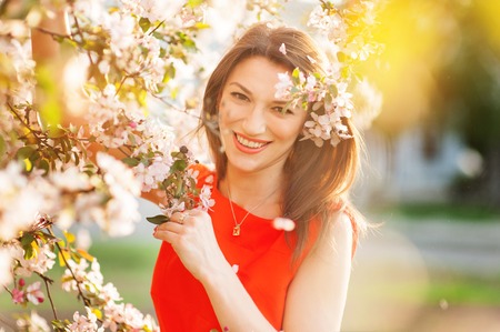 Sensual portrait of spring woman, beautiful face female enjoying cherry blossom, tree branch and glamorous ladyの写真素材