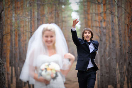 bride and groom walking in a pine forest.の写真素材