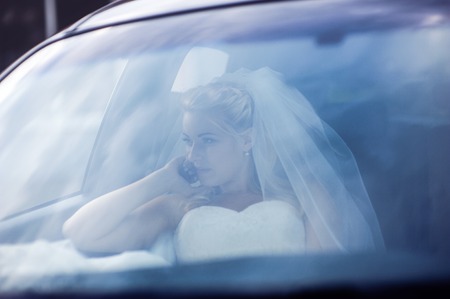 Portrait of the bride through the glass of the carの写真素材