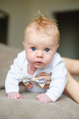 little baby boy lying on soft blanket in room.の写真素材