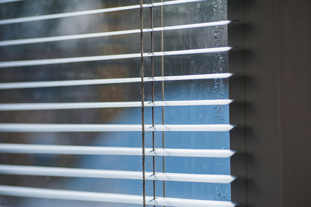 Sunlight coming through venetian blinds by the window.の写真素材