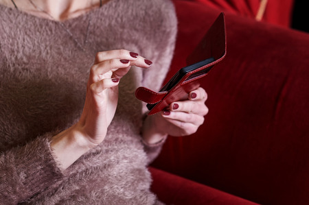 Closeup woman hand typing on smart phone.
