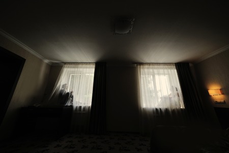 bride and groom sitting on the windowsの写真素材