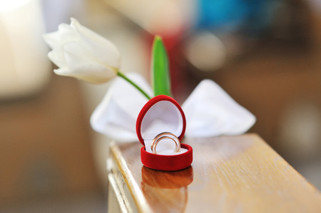 wedding rings in a heart shaped box and flower.の写真素材