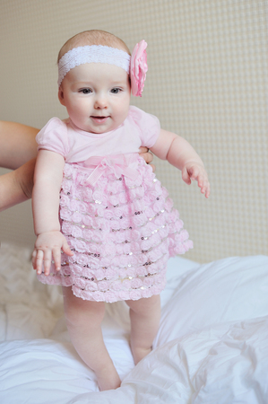 Adorable little baby girl sitting on the floor studio shot lovely portrait.の写真素材