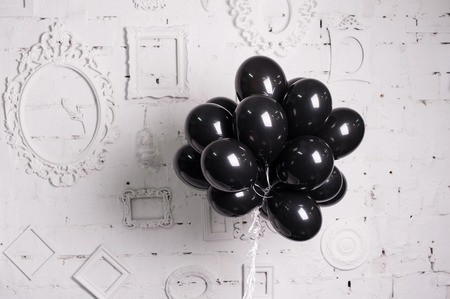 black balloons against a white wall with frames.の写真素材