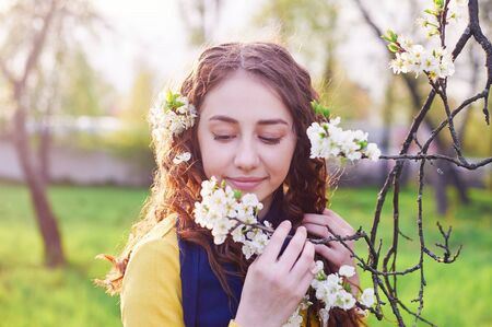 young beautiful woman in the blossoming spring garden.の写真素材