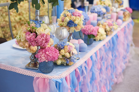Table set for wedding reception with candles and flower bouquets.の写真素材