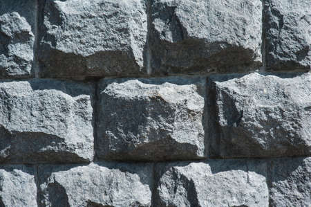 old wall of large black different stones surface background.の写真素材