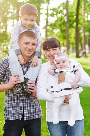 happy young family walks in the summer park.の写真素材
