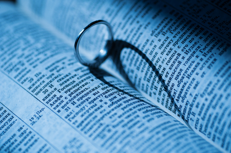 golden ring makes heart shaped shadow in book.の写真素材