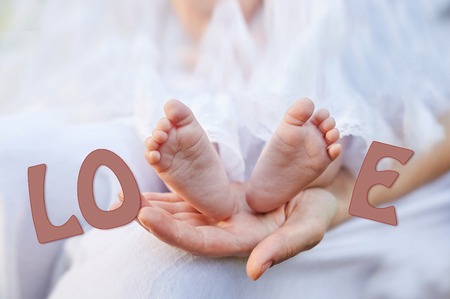 mother hand holding small baby feet close up
