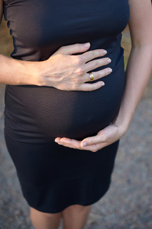 pregnant woman holding her hands on her belly stomach.の写真素材