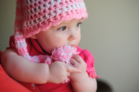 little girl in pink knitted hatの写真素材