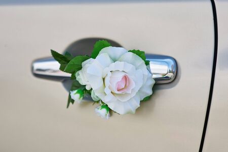 white rose flower on the handle of a car in wedding dayの写真素材