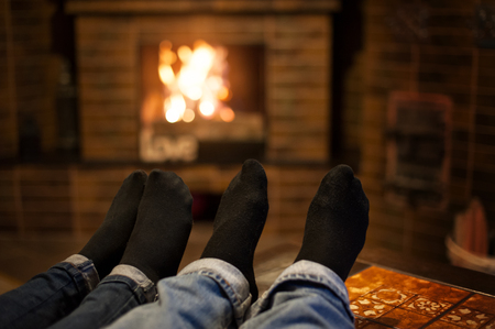 Close up of romantic legs in socks in front fireplaceの写真素材