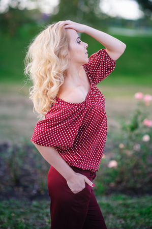 beautiful young woman walking in a summer parkの写真素材