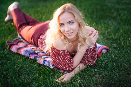 beautiful young woman lying on the grass in the parkの写真素材
