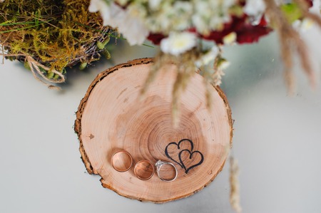 wedding rings on a wooden stump in a rustic styleの写真素材