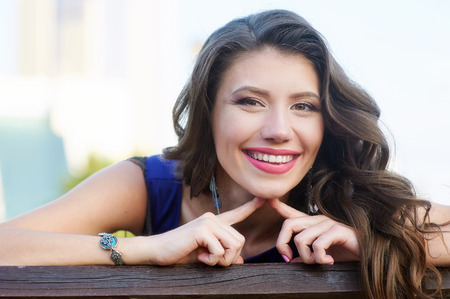 Beautiful brunette woman sitting on bench in parkの写真素材