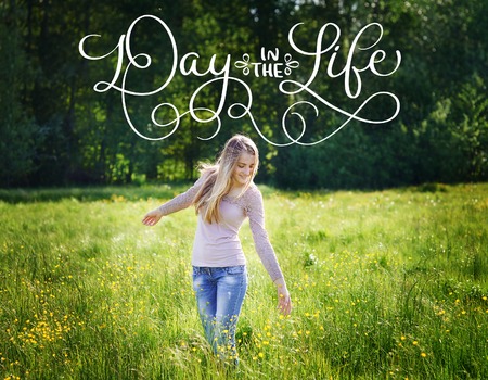 happy beautiful woman walking on a spring meadow and text Day in the life. Calligraphy lettering vintage hand drawの写真素材