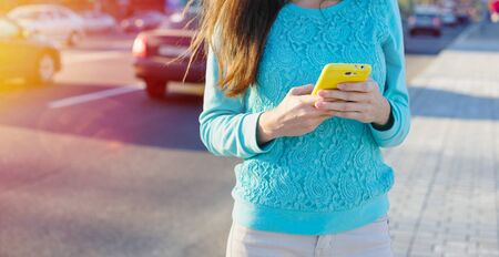 young woman with smartphone writes