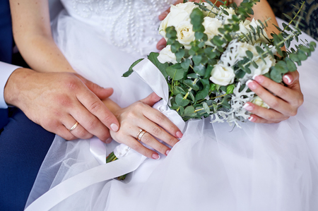 groom embraces the bride with a wedding bouquet of flowers for a walkの写真素材