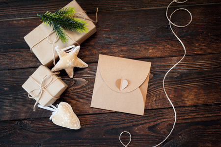 Christmas Composition set of gift kraft boxes, textile toys and cord frame on wooden backgroundの写真素材
