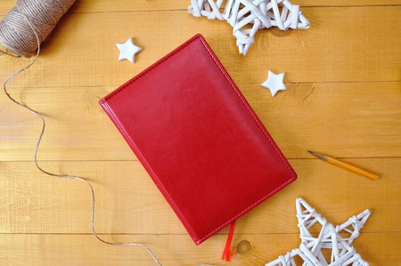 Christmas background red notepad for your text and white christmas star a wooden background. Flat lay, top view photo mockupの写真素材