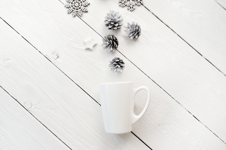Mockup white cup with christmas decorations, on a white wooden background. Flat lay, top view photo mock upの写真素材