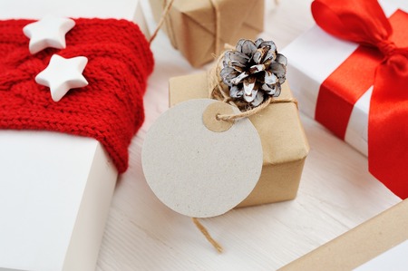 Mockup christmas kraft gift boxes and tag on wooden boardの写真素材