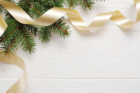 Mockup Christmas tree and gold ribbon, flatlay on a white wooden background, with place for your textの写真素材