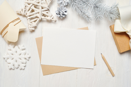 Mockup Christmas greeting card letter in envelope with white tree, flatlay on a white wooden background, with place for your text, Flat lay, top view photo mock upの写真素材