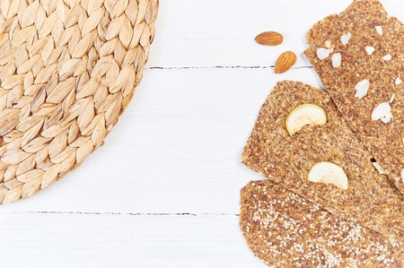 Bread with flaxseeds and almonds on a white wooden background. Useful dietary raw bread vegan breakfast without yeast.の写真素材
