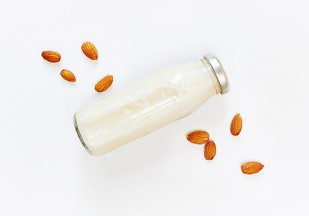 Almond milk and almond seeds over white background, vegetable milk, the concept of proper nutrition raw food vegan.の写真素材
