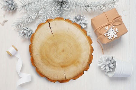 Christmas abstract background. White sheet of paper lying among small decorations on white wooden desk. Flat lay mockup for your art, picture or hand lettering composition copy space, top viewの写真素材