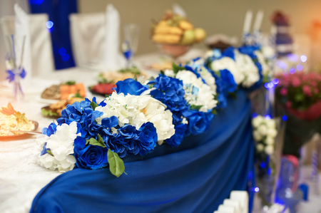 wedding decor of white flowers on the table of the bride and groom in the restaurantの写真素材