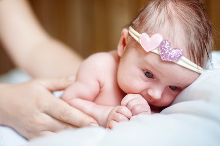 Mom puts a newborn baby girl to sleepの写真素材