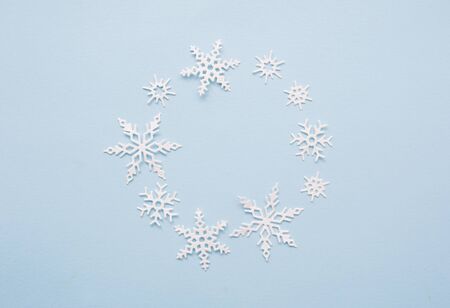 Christmas or winter composition wreath. Frame of white snowflakes on pastel blue background. Christmas, winter, new year concept. Flat lay, top view, copy spaceの写真素材