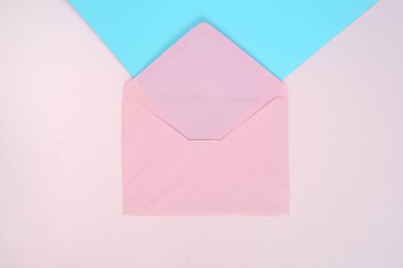 Open pink envelope on pink and blue background. Top viewの写真素材
