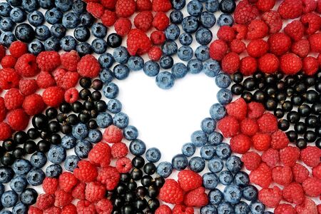 Summer blueberry, raspberries and currant heart frame detox isolated on white background. Love berries border design. Close up top view or flat lay with place for your textの写真素材